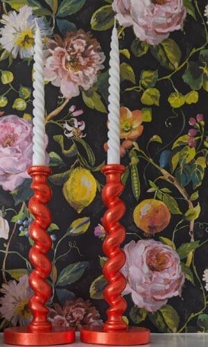 orange candlesticks against dark floral background