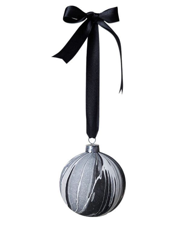 Black, white, grey and silver marbled bauble hanging on a black satin ribbon tied in a bow